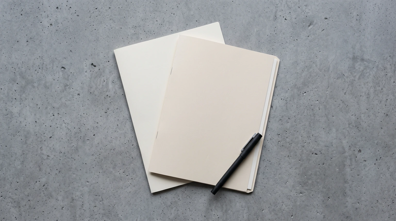 Two overlapping paper folders on a concrete surface