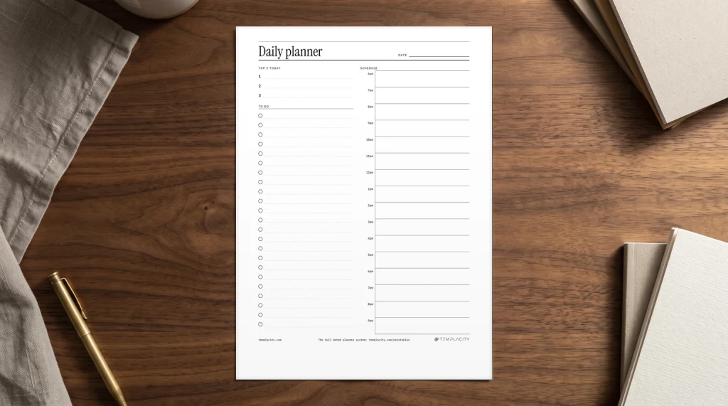 Our free printable daily planner on a desk: the top three, a to do list and an hourly schedule, printed on US Letter